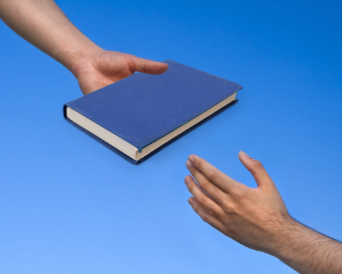 hand from above with book hand from below wants it